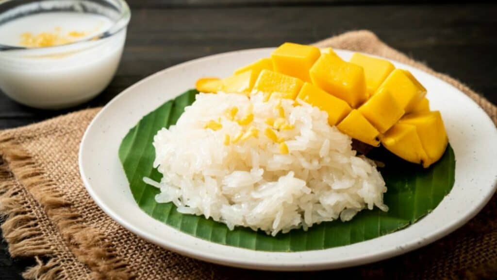 Image of Mango Sticky Rice, which is sticky rice, served with slices of mango and topped with sweet milk.