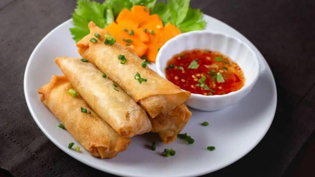 image of a plate with Poh Pia tod, which are small eggrolls with a chili dip that is often sold at local street food stalls in Thailand